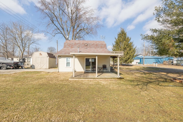 rear view of house with a yard, a shed, and an outbuilding