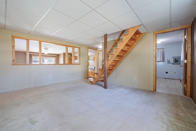 basement with carpet floors, stairs, and a drop ceiling