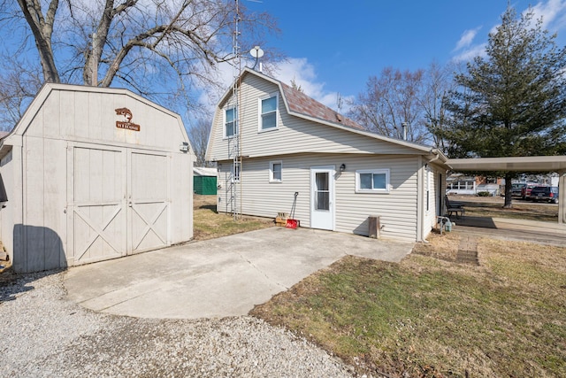 exterior space with a storage shed, a yard, an outdoor structure, and a gambrel roof