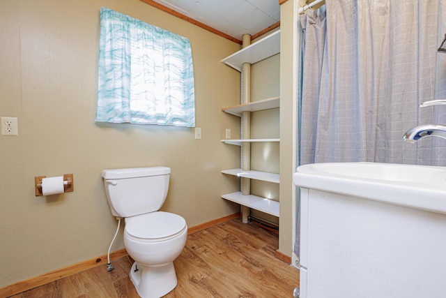 bathroom featuring toilet, curtained shower, baseboards, and wood finished floors