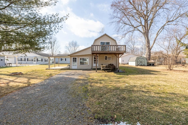 view of front of house with an outdoor fire pit, a gambrel roof, an outbuilding, a shed, and a front lawn