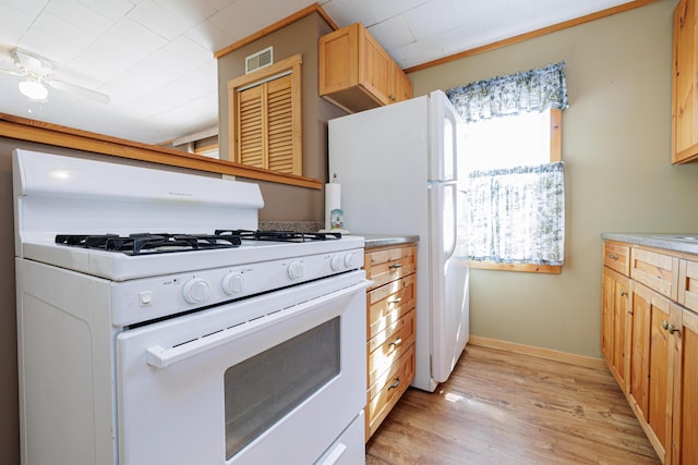 kitchen featuring white gas stove, visible vents, baseboards, light wood-type flooring, and light brown cabinetry