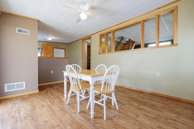 dining space with wood finished floors, visible vents, and baseboards