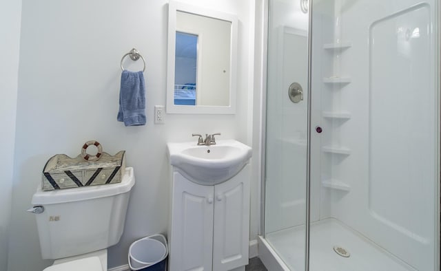 bathroom with a shower stall, toilet, and vanity