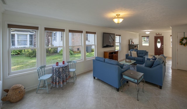 living area featuring light tile patterned floors, ornamental molding, a wealth of natural light, and baseboards