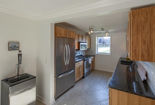 kitchen with tasteful backsplash, appliances with stainless steel finishes, light tile patterned flooring, and crown molding