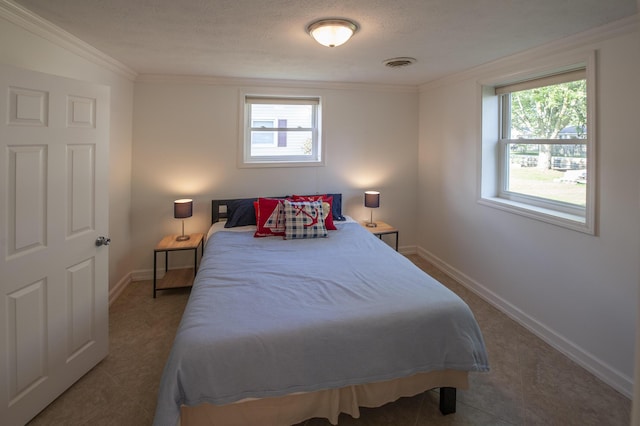 bedroom with multiple windows, visible vents, and crown molding