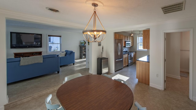 dining space with a chandelier, visible vents, and crown molding