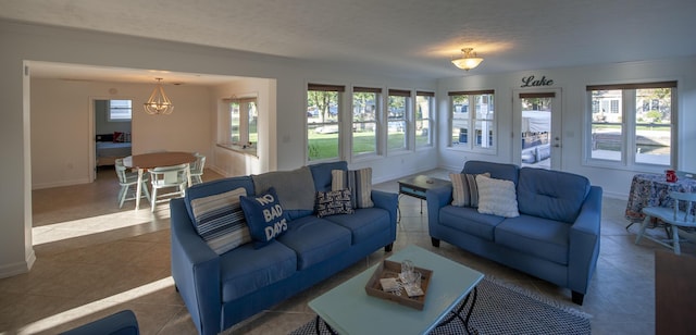 tiled living area with a textured ceiling and baseboards