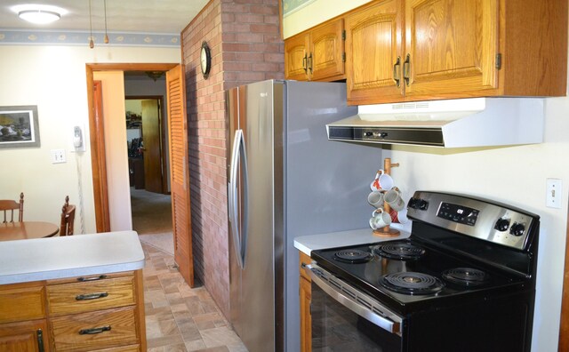 kitchen with brown cabinetry, stone finish flooring, light countertops, stainless steel range with electric cooktop, and under cabinet range hood