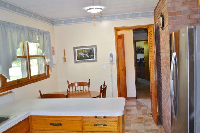 kitchen featuring a peninsula, light countertops, and freestanding refrigerator