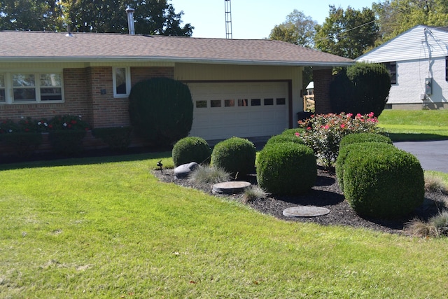 single story home with a garage, brick siding, a front yard, and a shingled roof