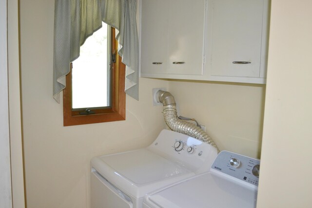 washroom with washing machine and dryer and cabinet space