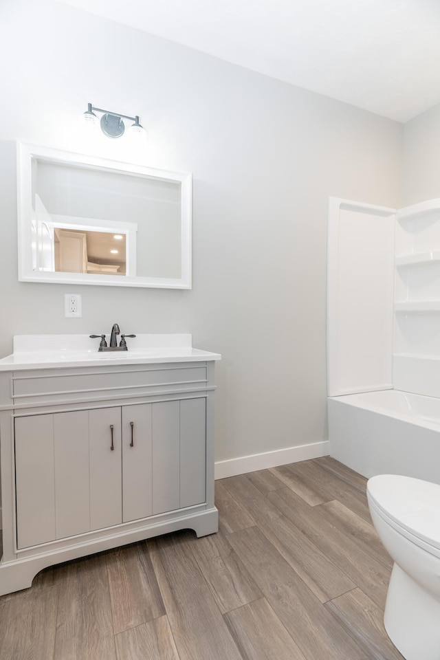 404 N Main St, Jackson Center, OH 45334 - full bath with wood finished floors, vanity, toilet, a bath, and baseboards