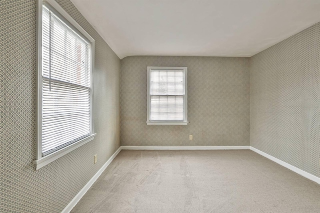 spare room with baseboards and carpet