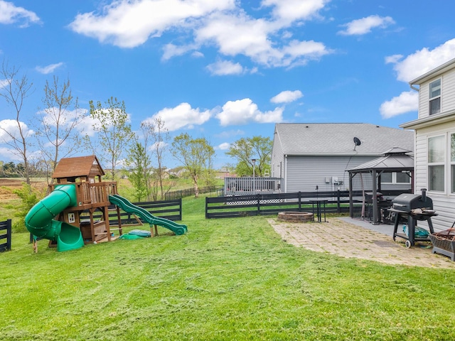 view of yard featuring a fire pit, fence, a gazebo, a patio, and a playground
