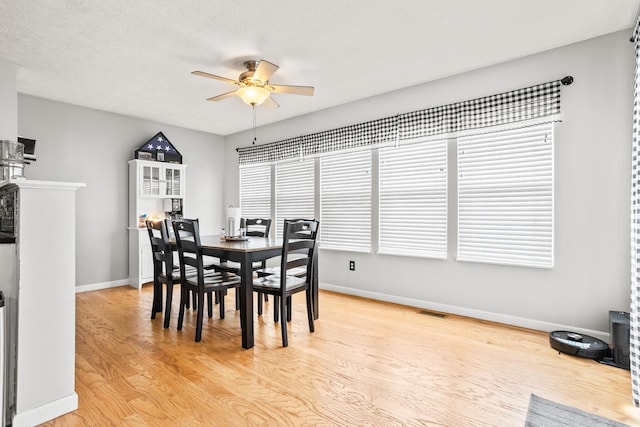 dining space featuring visible vents, ceiling fan, light wood-style flooring, and baseboards