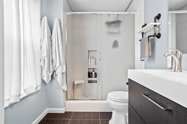 full bath featuring a shower stall, baseboards, toilet, wood finished floors, and vanity