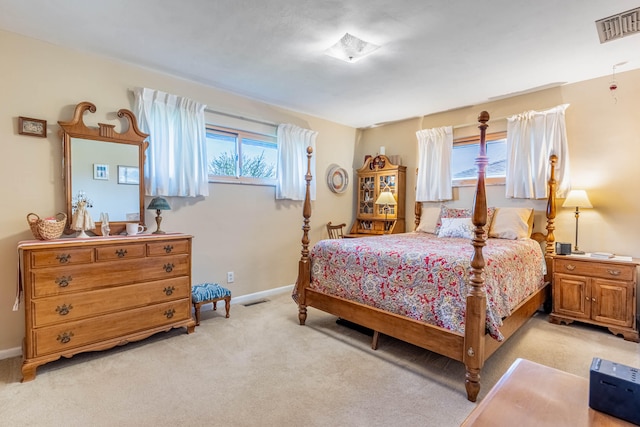 bedroom featuring visible vents, baseboards, multiple windows, and light colored carpet
