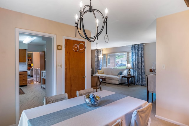 dining area featuring light carpet and a notable chandelier