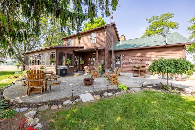 8339 Hite Rd, West Liberty, OH 43357 - back of property with a fire pit, a patio area, a sunroom, and a yard