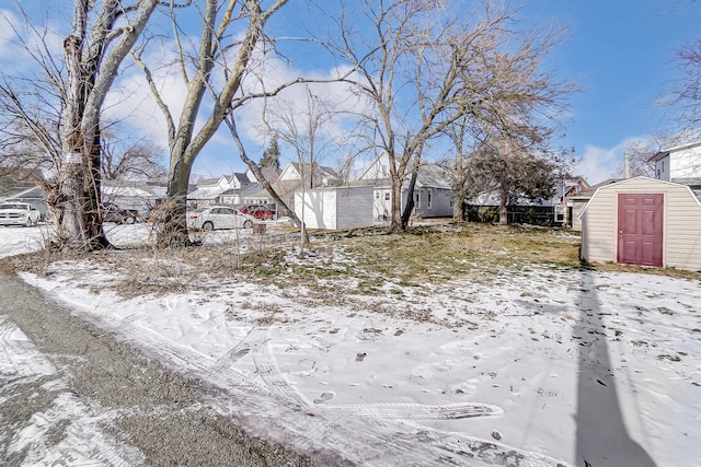 yard covered in snow featuring a shed