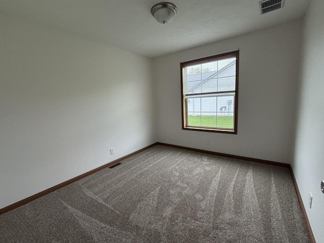 spare room featuring baseboards, carpet flooring, and visible vents