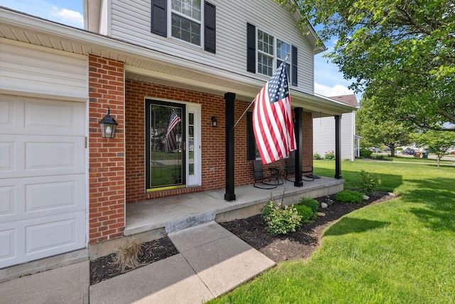 2909 W Barnhill Pl, Xenia, OH 45385 - view of exterior entry featuring a porch, a lawn, and brick siding
