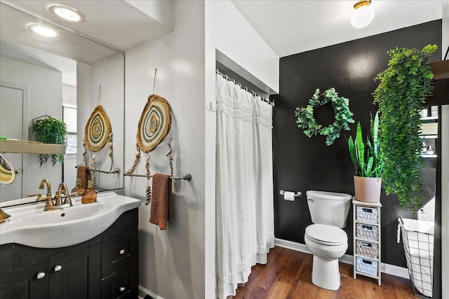 full bath with vanity, toilet, wood finished floors, and baseboards