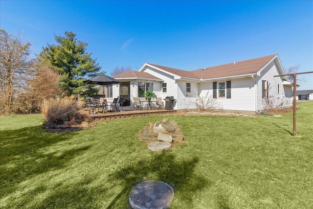 rear view of property with a lawn and a patio area