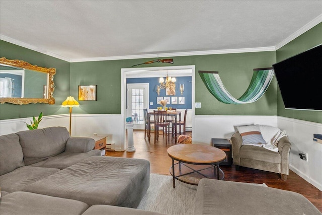 living area with a wainscoted wall, ornamental molding, and wood finished floors