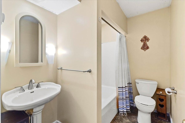 bathroom featuring toilet, shower / bath combo, and a sink