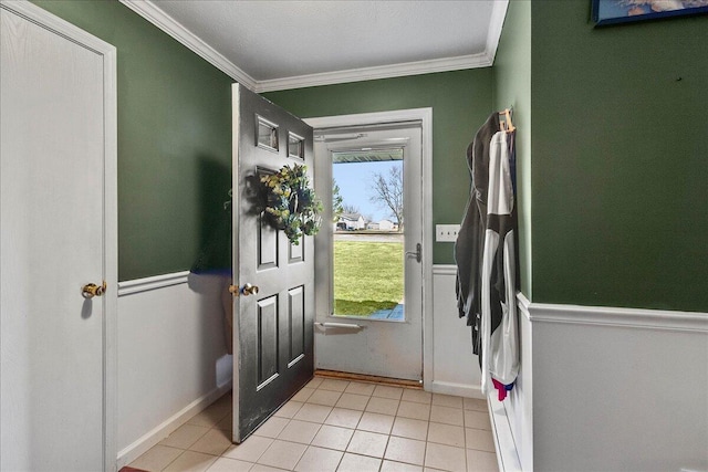 doorway to outside with light tile patterned floors, wainscoting, and crown molding