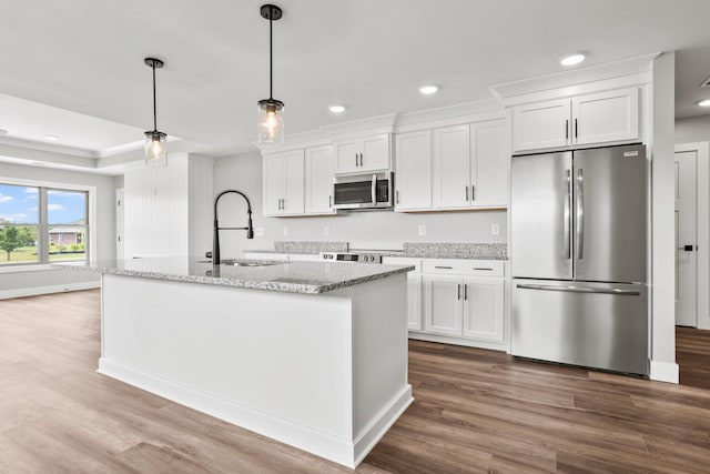 1160 Waterloo St, Troy, OH 45373 - kitchen featuring appliances with stainless steel finishes, white cabinetry, wood finished floors, recessed lighting, and a kitchen island with sink