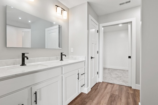 1160 Waterloo St, Troy, OH 45373 - bathroom featuring double vanity, wood finished floors, and recessed lighting