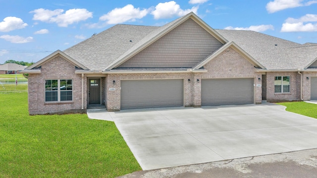 1160 Waterloo St, Troy, OH 45373 - view of front of house featuring an attached garage, driveway, a front yard, a shingled roof, and brick siding