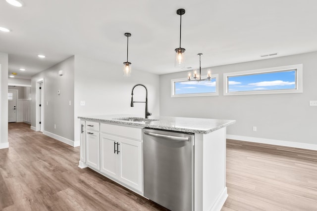 1160 Waterloo St, Troy, OH 45373 - kitchen with stainless steel dishwasher, light wood-style flooring, white cabinets, hanging light fixtures, and light stone counters