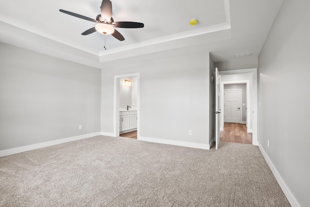 1160 Waterloo St, Troy, OH 45373 - unfurnished bedroom featuring a tray ceiling, carpet flooring, ensuite bathroom, and ceiling fan