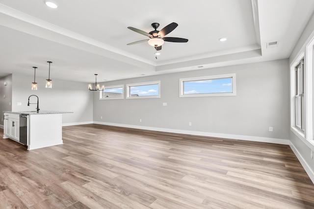 1160 Waterloo St, Troy, OH 45373 - unfurnished living room featuring a raised ceiling, ceiling fan, wood finished floors, a chandelier, and recessed lighting