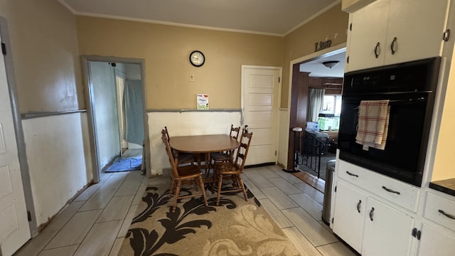 kitchen with dark countertops, oven, wood tiled floor, and white cabinetry