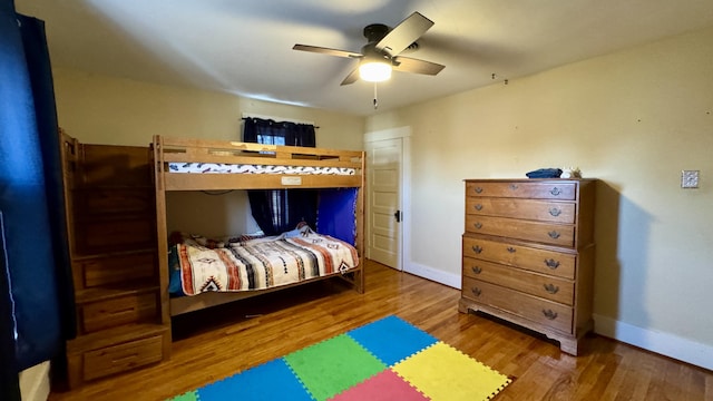 bedroom with wood finished floors, a ceiling fan, and baseboards