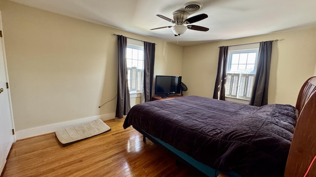 bedroom with a ceiling fan, baseboards, and wood finished floors