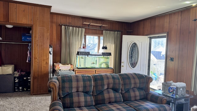 living area with light carpet, crown molding, and wooden walls