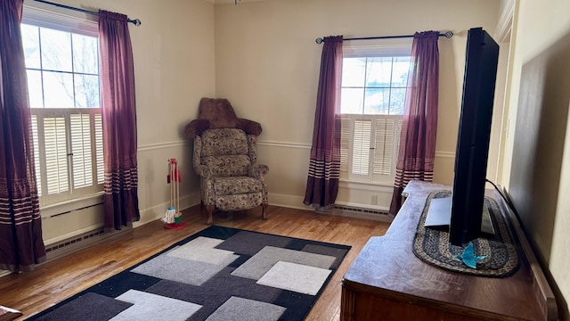 living area featuring wood finished floors, visible vents, and baseboards