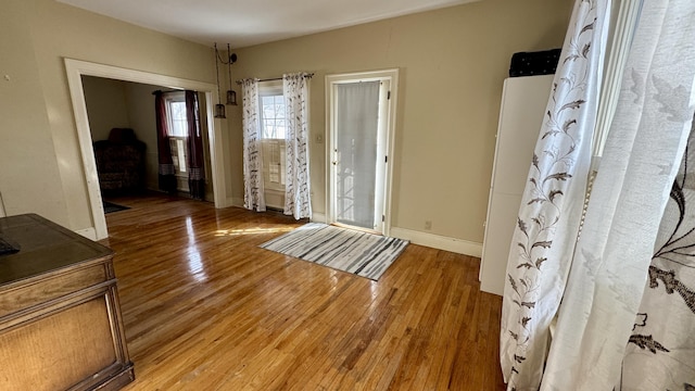 entrance foyer with baseboards and light wood finished floors