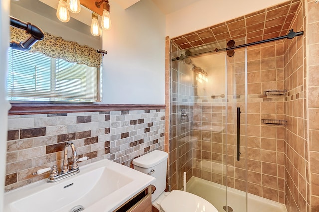 bathroom featuring tile walls, toilet, a stall shower, wainscoting, and vanity