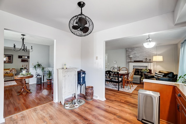 kitchen with light wood-style flooring, a fireplace, brown cabinets, and open floor plan