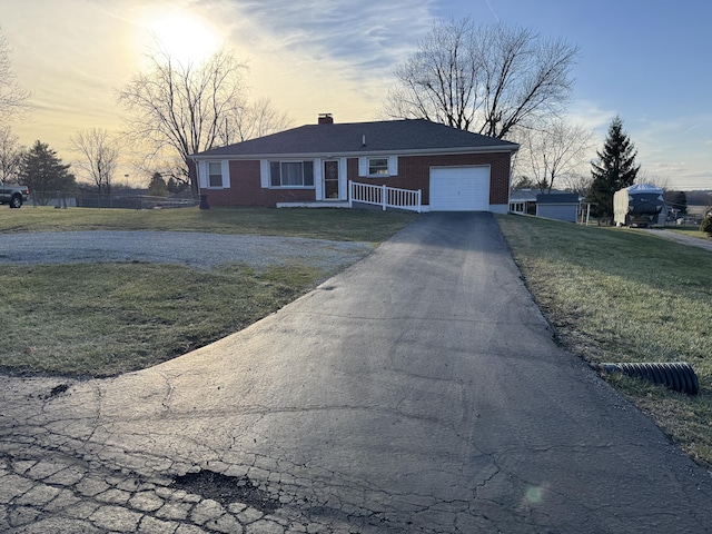 ranch-style home with a yard and a garage