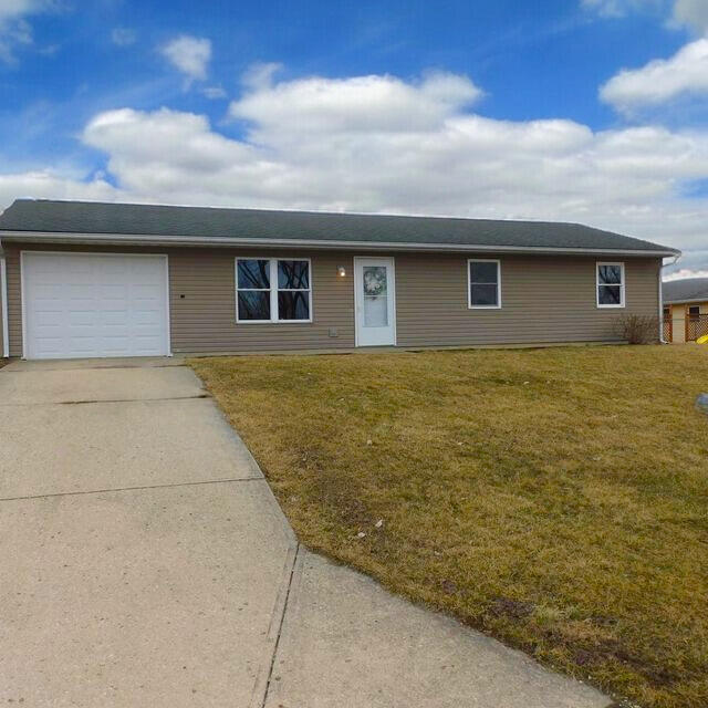 ranch-style house with a garage, driveway, and a front lawn