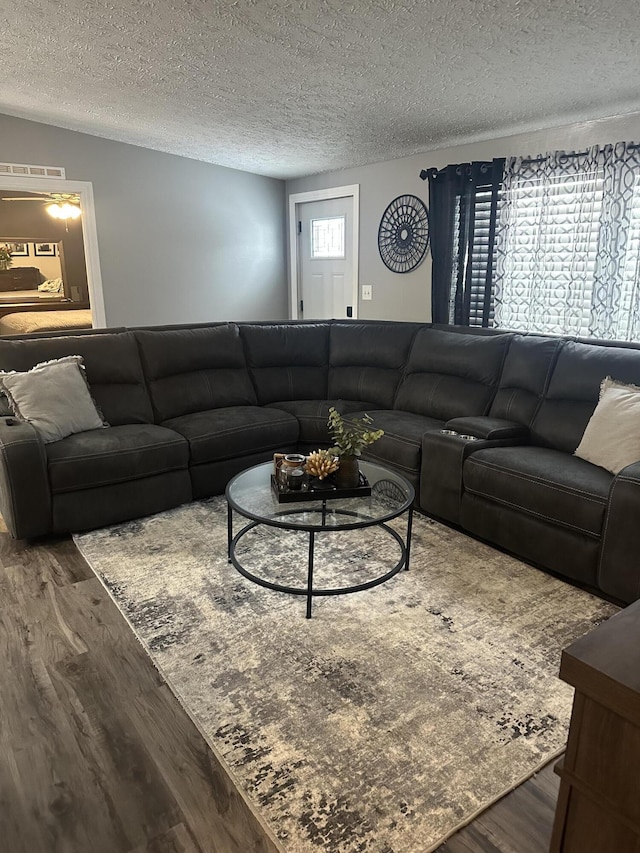 living area with a textured ceiling and wood finished floors